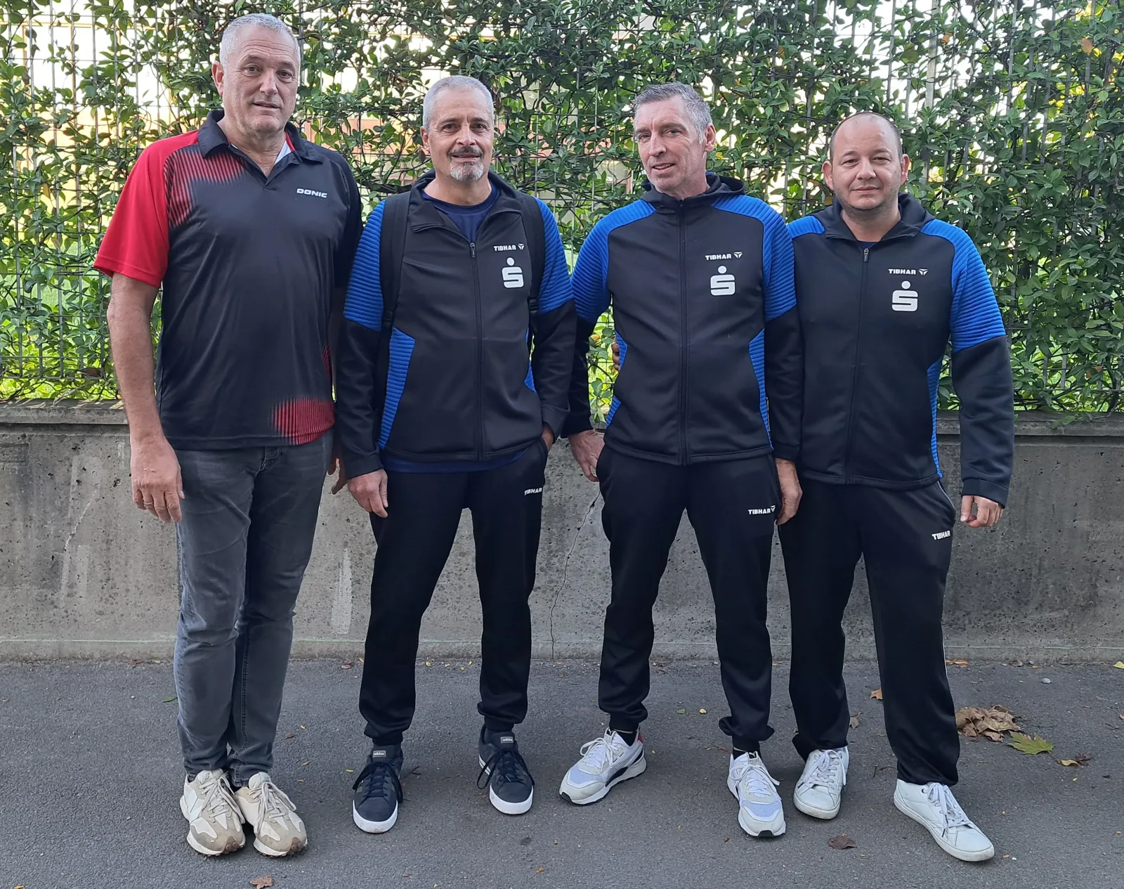 Vier Spieler des TSV 1990 Merseburg in Vereinsjacken vor der Halle